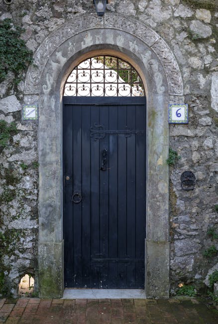 Ancient arched door with number six